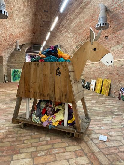 Trojan donkey, mad from found material, carries discarded cloth, sustainability, saving resources, memorial to society